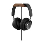 Walnut and aluminium headphone stand holding over-ear headphones